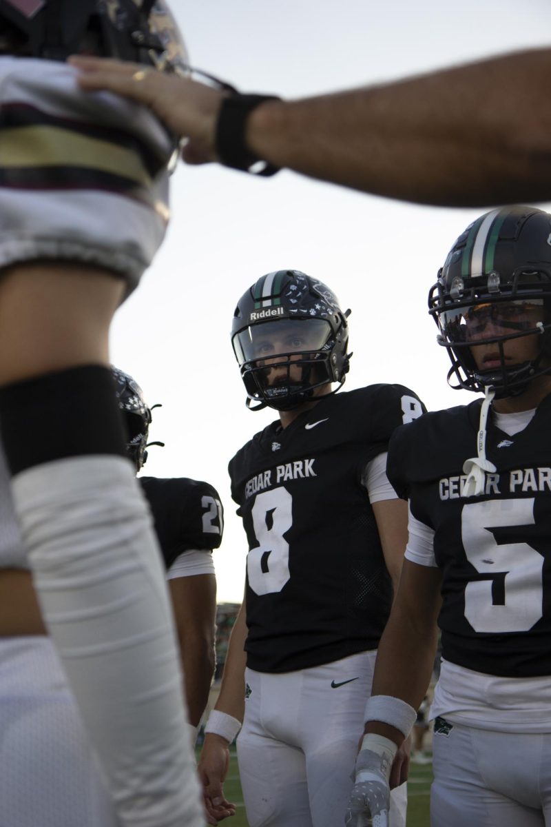 Staring down his opponents during the pregame coin toss, sophomore varsity quarterback David Cooper readies himself for the Homecoming game against Rouse High School on Oct. 10. The game ended in a 35-25 win for the Timberwolves. “I’m observing the guys I am going to be playing against,” Cooper said. “Before the game, I like to think about what I am going to have to do to win the game and get in the zone. A lot of mental focus is needed before the game and I prepare myself for what is going to happen.” Photo by Kacey Miller