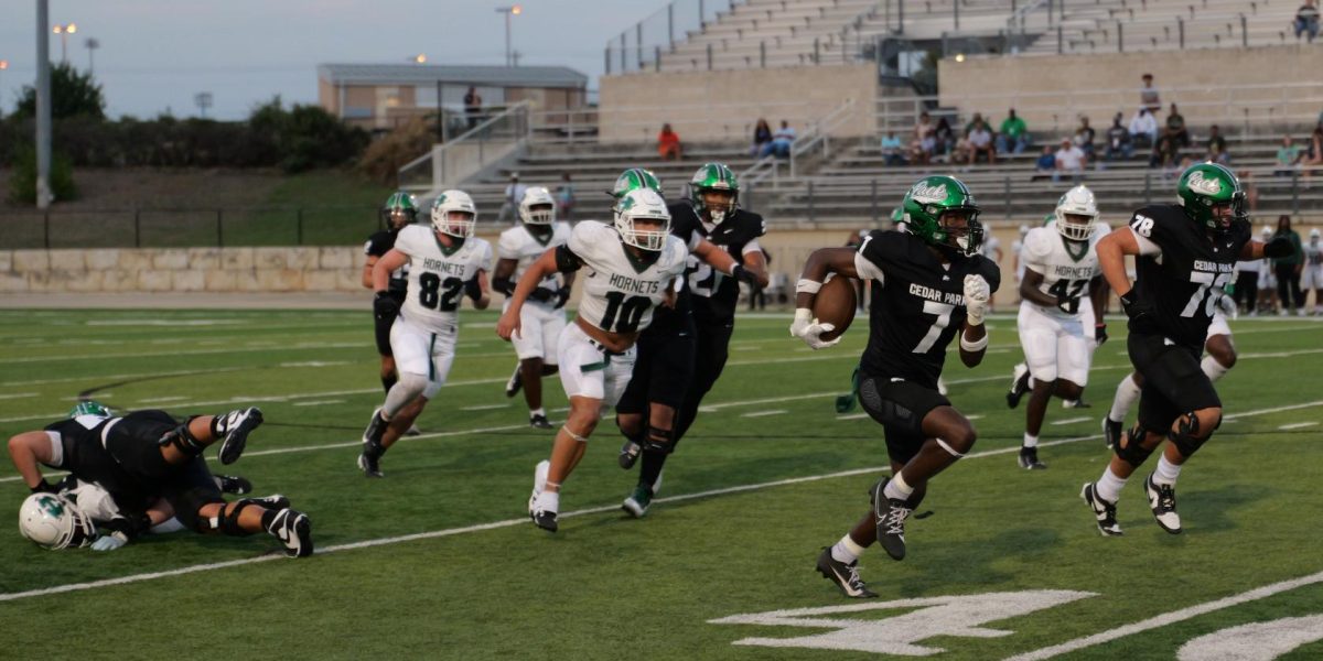 Running with the ball under one arm, junior and varsity tight end Jamal Porter rushes the ball for a touchdown. The theme for the game against Huntsville was Gold Out. “When scoring a touchdown, it feels amazing to know you did something for your entire team,” Porter said. “I prepare for my position by going to practice, practicing everyday and doing what I am supposed to do.” Photo by Willa Pursley