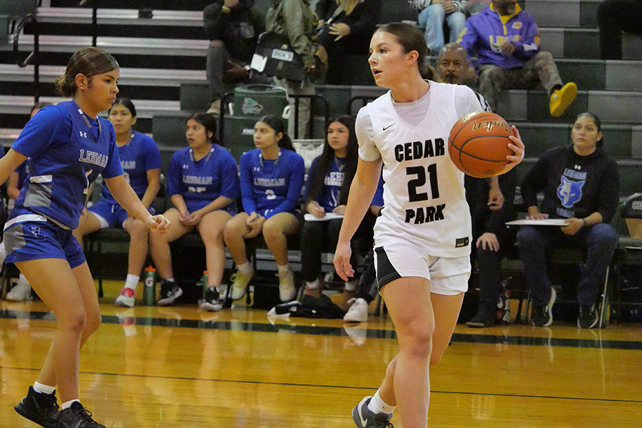 Looking past a defender, junior Ahnna Breiner searches for a teammate to pass the ball to. The girls basketball team started district play on Dec. 10 and is now 3-0 in district and 15-3 overall. "I feel really good," Breiner said. "We've been winning a lot and playing more as a team. Our team chemistry is very good, and I'm very confident going into district."