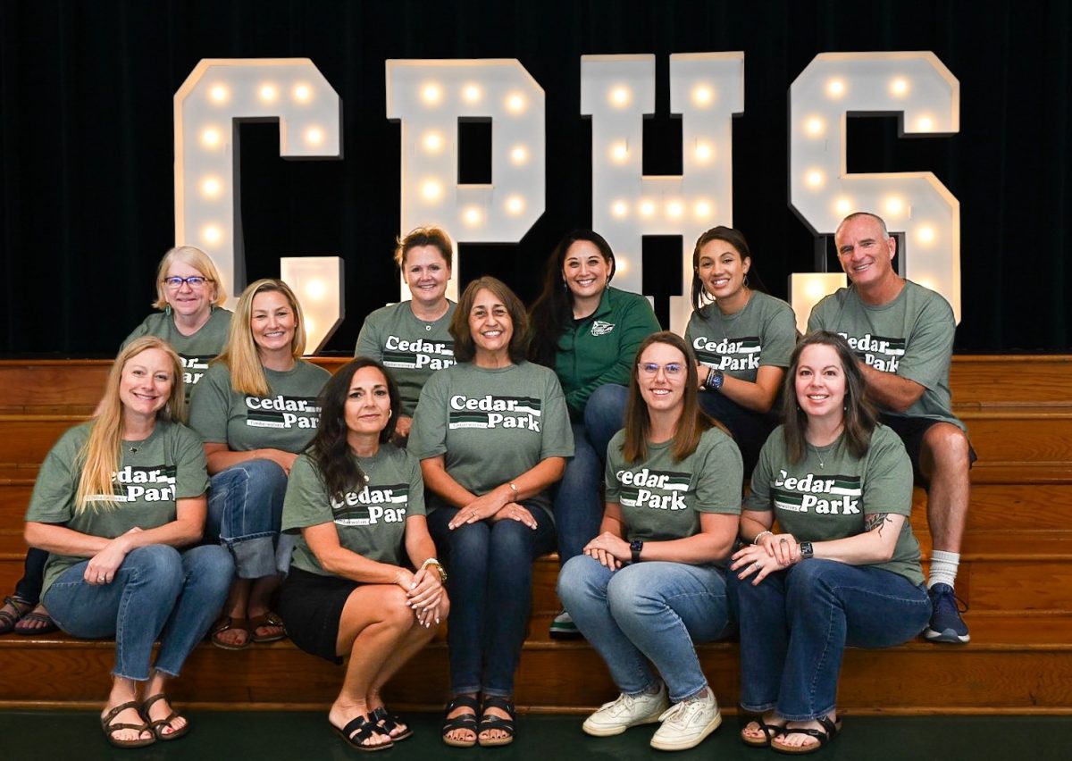 As the support team sits and poses for a photo in the cafeteria with the counseling team they eagerly wait to start their day. "We [all] seem to be a team, I get up every day and there's days where I don't want to go to work today, but I'm thankful that I have a job and I'm blessed to have what I have," Christopherson said. Photo Courtesy of Julie Weltens.
