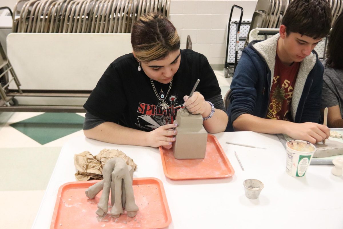 Sculpting a clay figure, sophomore Adrianna Frezza participates in CP Night, an event where students and parents explore the clubs and courses offered at CPHS. She represented the art club, showcasing her passion for creativity and hands-on learning. "I saw CP Night as both a great way for students to represent and talk about the things they're passionate about, and incoming students/parents to figure out the different programs CPHS offers," Frezza said. "It was a super fun experience, and I'm grateful I got the opportunity to talk about our school's art courses." Photo by Mia Morneault