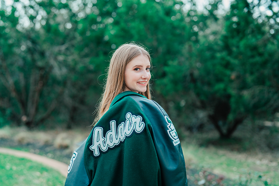 With her varsity jacket wrapped around her shoulders, senior Charlotte Adair smiles for her senior photos. She will attend the University of Texas at Austin with a major in theater and dance, specifying in stage management. “There's only so many regional and big productions out there, but the opportunities that I hopefully will be able to receive are going to be really awesome, fingers crossed,” Adair said. “We are very lucky at Cedar Park High School to be able to do so many shows and have a pretty good budget for most of them, but then you go and see Broadway shows and they have crazy projections and moving set pieces. The possibility of being able to help with that is something that I'm very much looking forward to.”
Photo by Melissa McKinney