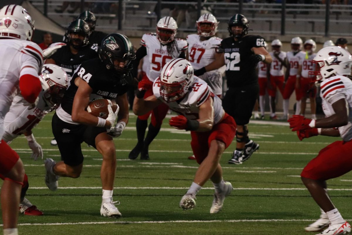 After making a catch, junior receiver Brayden Jahns runs towards the end zone, dodging defenders at the football game against Harker Heights on Friday. Jahns scored a touchdown in the game, which the Timberwolves lost 52-35. “It was during crunch time,” Jahns said. “We needed a score, so I made sure I got to the end zone.”