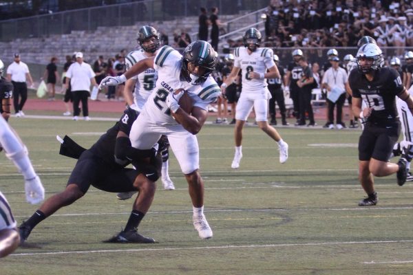 As he sprints with the ball, senior running back Trae Hill breaks a tackle during Friday’s 35-14 loss against the Vandegrift Vipers. Hill ran for 135 yards and two touchdowns during the game. “[Scoring] was electric,” Hill said. “It always feels good to score, but the O-line did everything.”