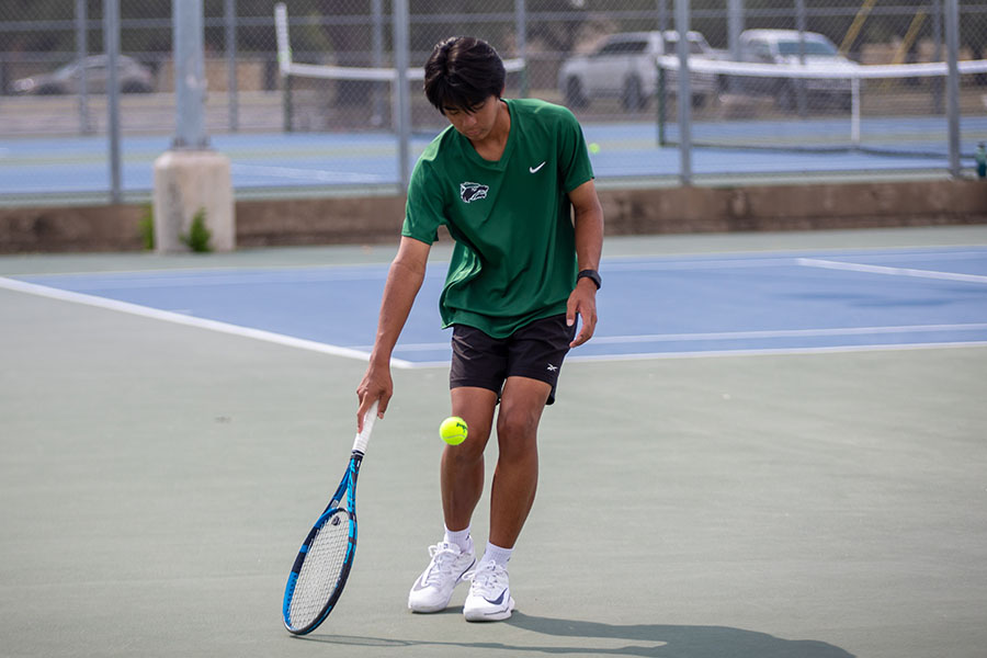 Looking down at his racket, junior Hasun Nguyen hits the green tennis ball. Hasun has played tennis since he was 9 years old, and he is on the varsity team. "I feel like it’s not really appreciated in America as much, but [tennis] is a really competitive and mentally challenging sport,” Nguyen said. “I’m really level-headed and can keep my cool during a match, and that helps me play a bit better under pressure.” Photo by Kyra Cox