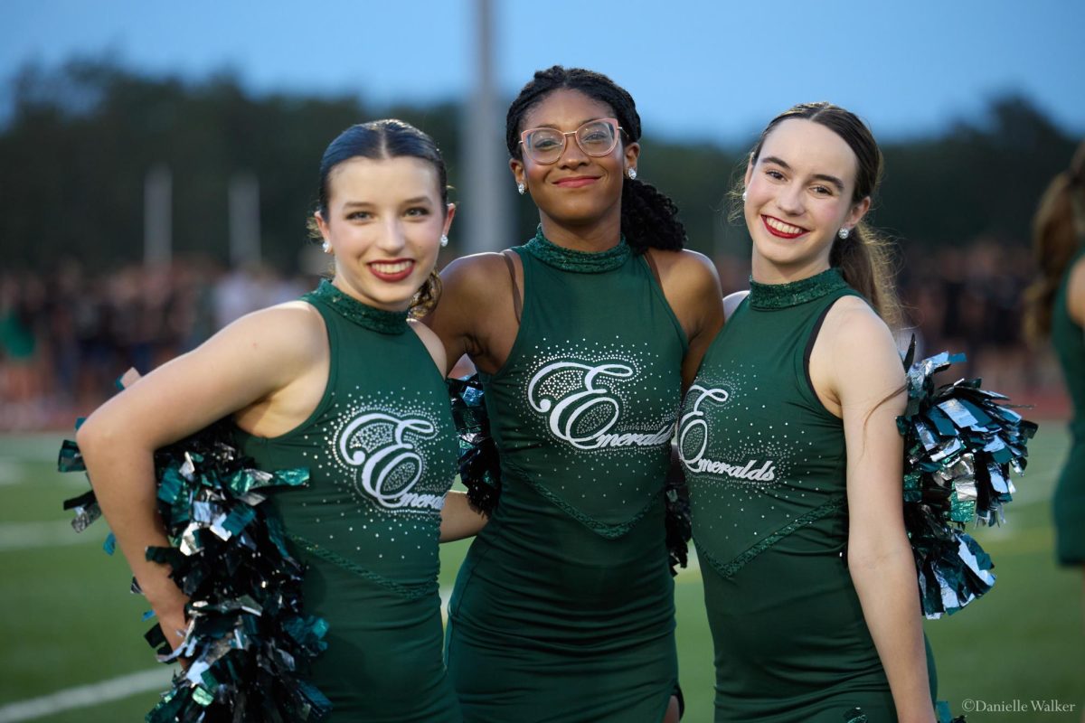 Smiling for the camera, senior Emeralds Ava Holmes, Lily Pratt, and junior Emilie Sander pose at Meet the Timberwolves, an annual event featuring the dance program. This is the first year that the Emeralds have been reinstated, after a five year period with no JV dance team, and this was one of the team's most recent public performances. "My favorite part of Meet the Timberwolves was dancing and performing with the Emeralds and Celebrities and welcoming all of the teams onto the field," Sander said. "It was so much fun, and it was a great way to show school spirit."
Photo courtesy of Danielle Walker