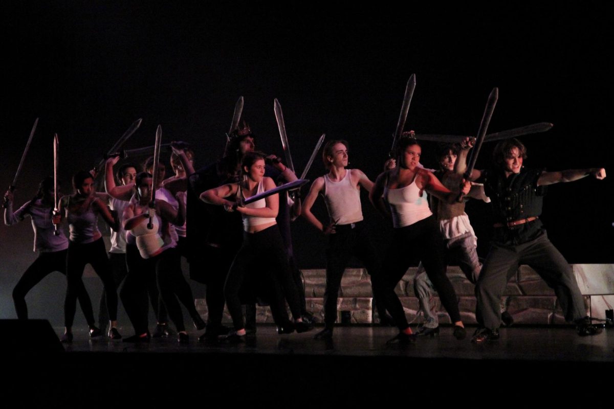 Holding swords, the “Pippin” ensemble runs through the play to prepare for opening night in two days, with the orchestra playing underneath their toes. Senior Sasha Rutledge  said she appreciates the orchestra. “The orchestra makes it really more alive like you’re in the moment,” Rutledge said. “I love having the orchestra. Having a professional, I think, was a fun, enjoyable decision made. I think it made it as unified as possible by having professional musicians.”