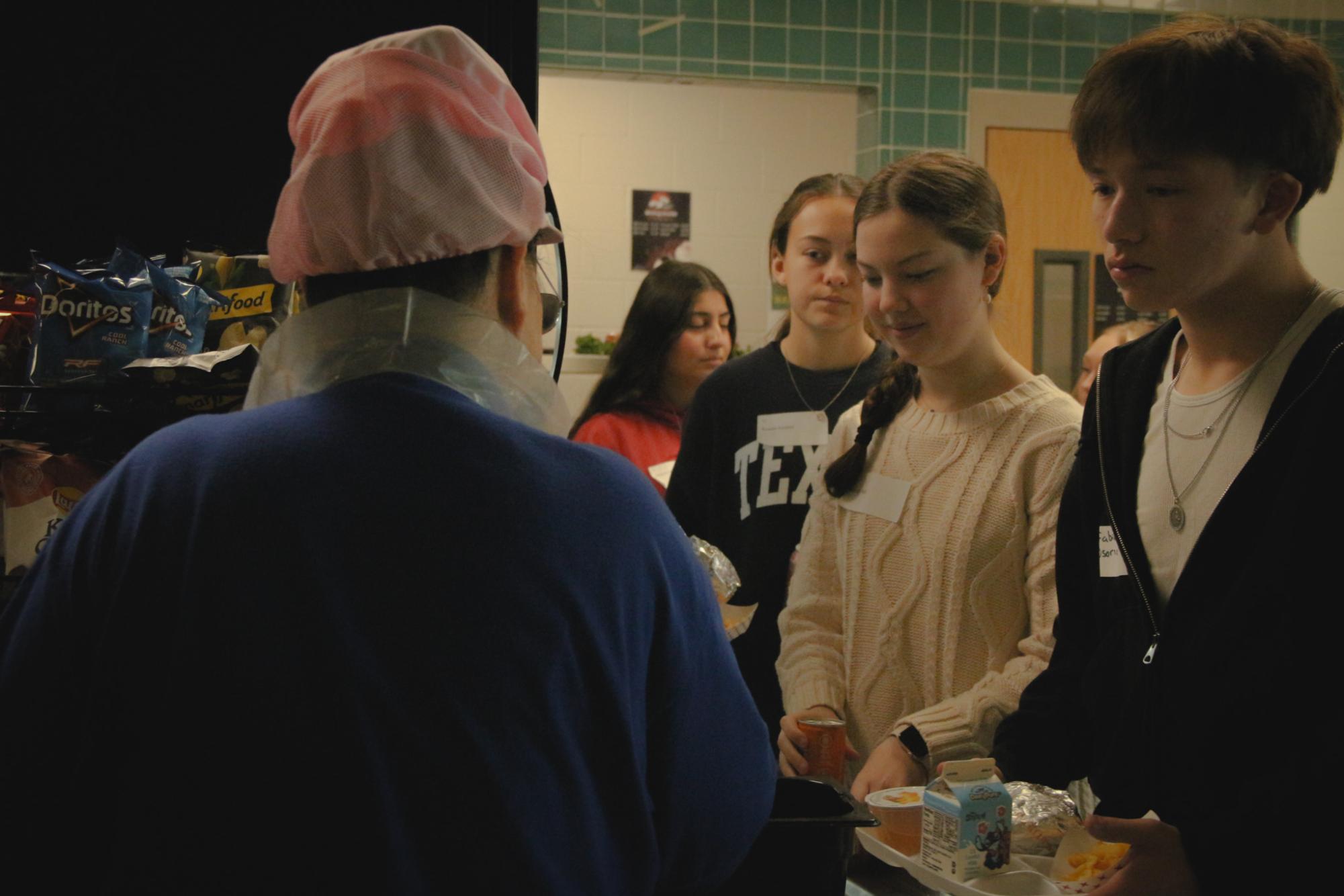 Middle schoolers get food from the high school lunchline, experiencing the high school lunch experience for the first time. All of the groups of eighth graders ate lunch first before starting on the tour led by PALS.  “I’m excited about making new friends in high school,”  Hope said.
