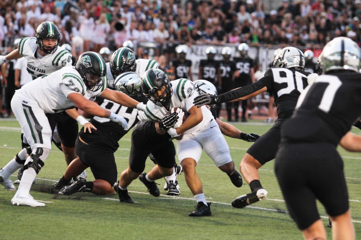 Evading defenders, junior running back Lucas Viloria runs towards the end zone while avoiding tackles at the game against Vandegrift on Sept. 5.