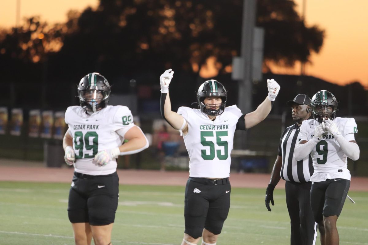 Arms raised high in the air, senior linebacker Jude Burke celebrates after a successful play alongside senior defensive lineman Brooks Bouffard on Oct. 17 against Glenn.