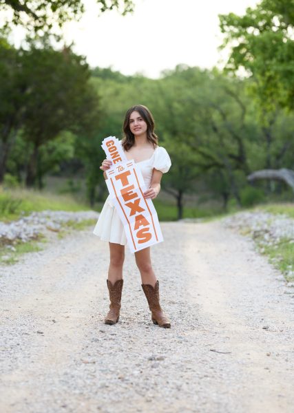 Standing with her “Gone to Texas” sign, senior Penelope Wilkinson poses for her senior photos after getting into the University of Texas at Austin, majoring in neuroscience. She is president of three clubs, a player on the district lacrosse team and is involved in several other extracurricular activities. “Whenever I do something good for my clubs or friends, just seeing their positive reaction really makes me feel good and like it’s worth it,” Wilkinson said. “It’s important to take time for yourself and focus on having good support systems and not just doing everything on your own.” Photo courtesy of Penelope Wilkinson